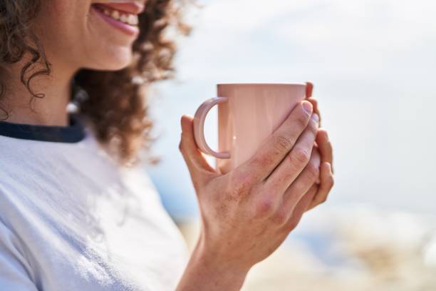 istock Young hispanic woman smiling confident drinking coffee at seaside 1446900915