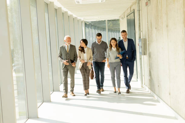 istock Group of corporate business professionals walking through office corridor 1446901075
