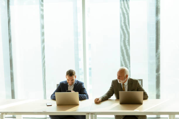 istock Businesspeople sitting and working in laptops at the office 1446901496