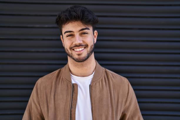 istock Young hispanic man smiling confident standing over black isolated background 1446902649