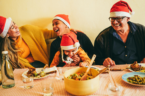 Happy latin family celebrating together during Christmas dinner - Focus on grandfather face