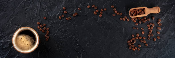 Coffee cup and beans panorama, overhead flat lay shot on a black background stock photo