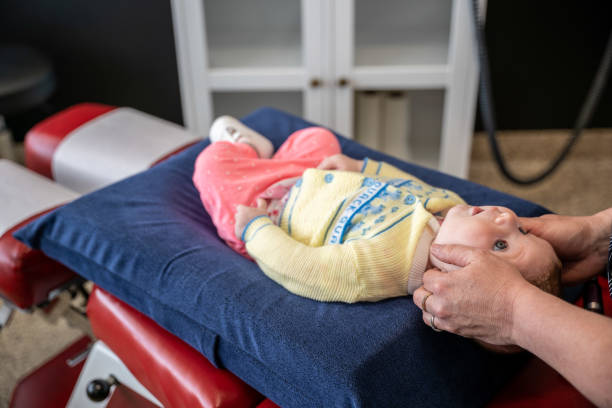bebê recebendo um exame quiroprático. - massaging alternative medicine headache women - fotografias e filmes do acervo