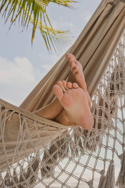 vacanza, uomo turista che riposa sull'amaca della spiaggia - hammock beach vacations tropical climate foto e immagini stock