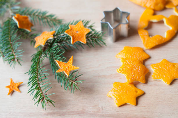 Great idea of festive activity for kids, zero waste handmade Christmas decorations  -  made by cutting star shapes from the scrap orange or other citrus peel. Once they dry can be used as ornaments to decorate any Christmas tree.