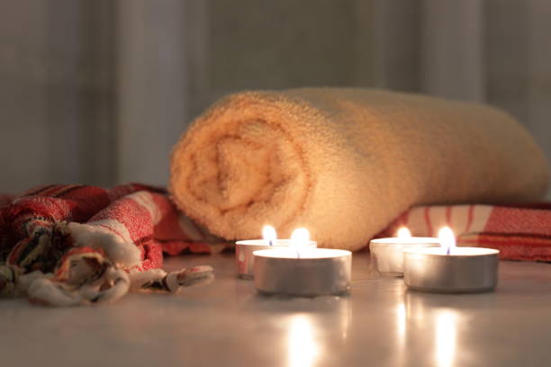 Close-up view of burning candles and towels on marble platform in Turkish bath
