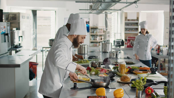 istock Professional chef adding grated parmesan cheese on food in pan 1446917098