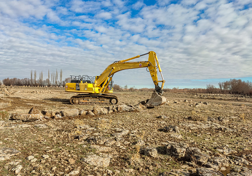 Heavy duty machines work in the field for construction work.