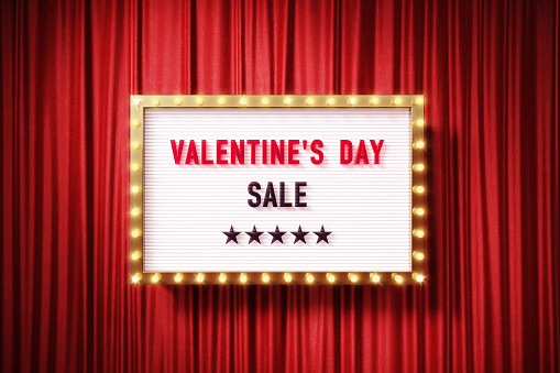 Valentine's Day Sale written retro billboard with glowing light bulbs on red curtain background with shadow. Horizontal composition. 3D rendering.
