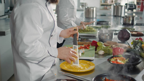 istock Male chef grating parmesan cheese on kitchen grater 1446917768