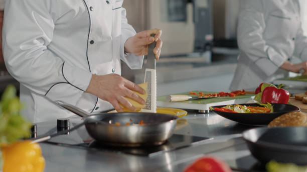 istock Professional chef using grater to add shredded cheese on dish 1446918022