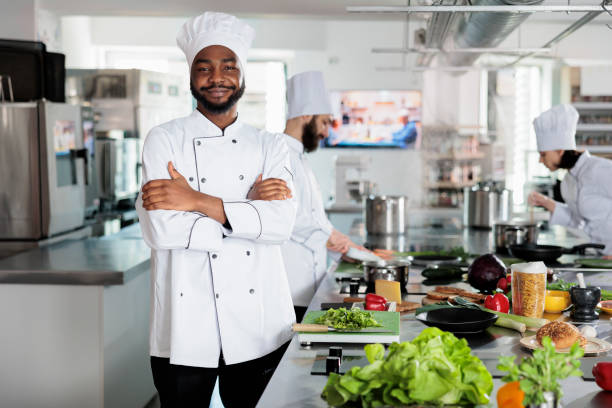istock Gastronomy expert standing in restaurant professional kitchen with arms crossed while smiling at camera. 1446919863