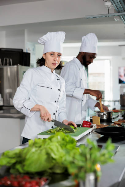 istock Multiracial food industry workers standing in restaurant professional kitchen while cooking tasty dish. 1446919928