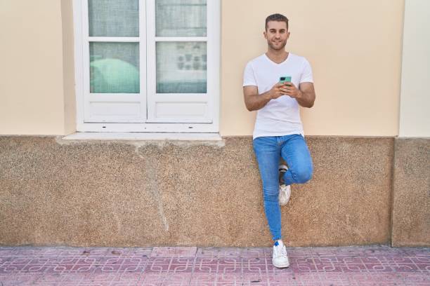 istock Young caucasian man smiling confident using smartphone at street 1446920499