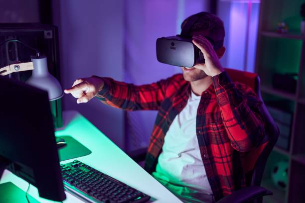 istock Young caucasian man streamer playing video game using virtual reality glasses at gaming room 1446920543