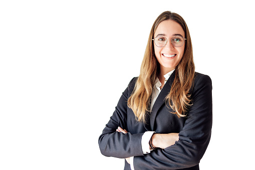 Young businesswoman in a suit smiling at the camera, looking professional with white background.
