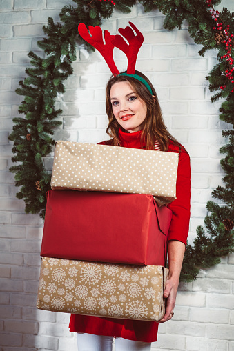 Portrait of a woman in Christmas costume holding presents.
