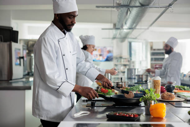 istock Sous chef cooking delicious gourmet dish while preparing meat in pan inside kitchen. 1446921452