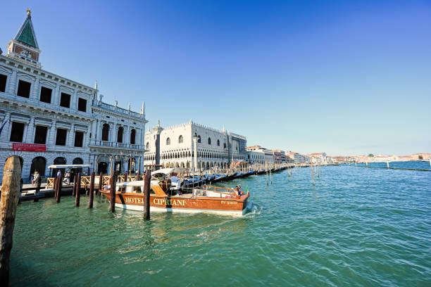 Venice, Italy - July 04, 2022: Gondolas docked and boats in harbour at Saint Marks, Venice, Italy.