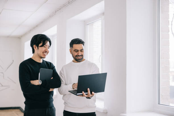 istock Two colleagues having a discussion at office hallway 1446921875