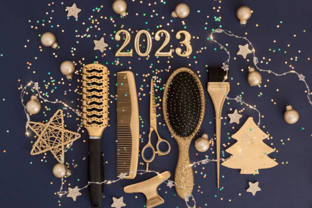 istock Figures 2023 scissors and comb with confetti on a dark background. Greeting card of hairdresser or hair salon. 1446922335