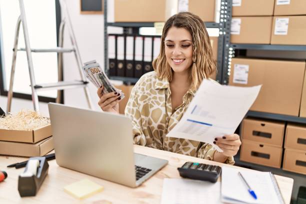 istock Young hispanic woman holding dollars and paperwork working at office 1446922781