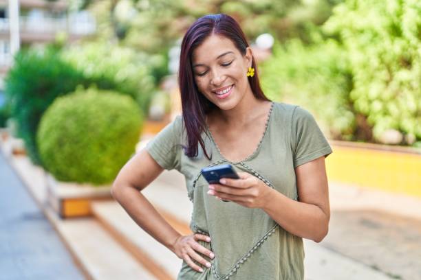 istock Young beautiful hispanic woman smiling confident using smartphone at park 1446923442