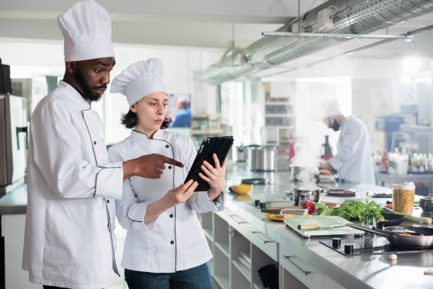 istock Food industry worker with handheld touchscreen device preparing ingredients for evening dinner service at restaurant. 1446923546
