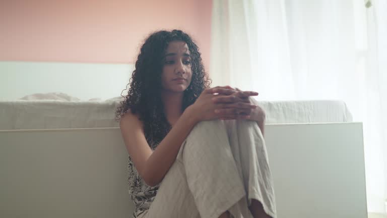 Young African American stressed woman in grief and looking away in distress.