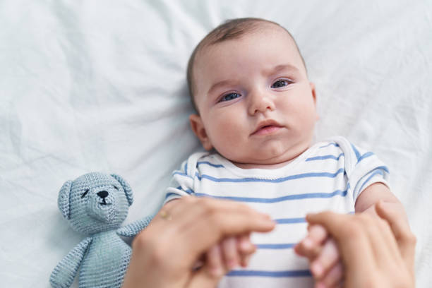 istock Adorable caucasian baby playing on bed with relaxed expression at bedroom 1446924220