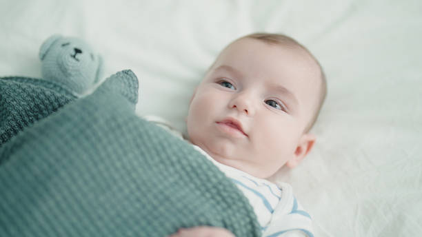 istock Adorable caucasian baby lying on bed with relaxed expression at bedroom 1446924238