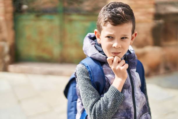 istock Blond child student standing with doubt expression at street 1446924362