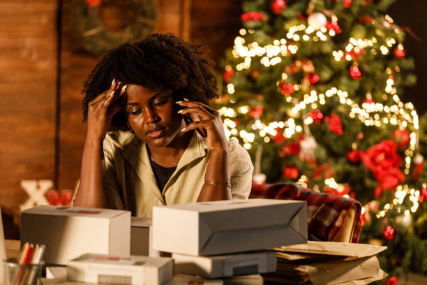 クリスマス休暇に働き、机で電話で話す圧倒された若い女性 - christmas emotional stress shopping holiday ストックフォトと画像