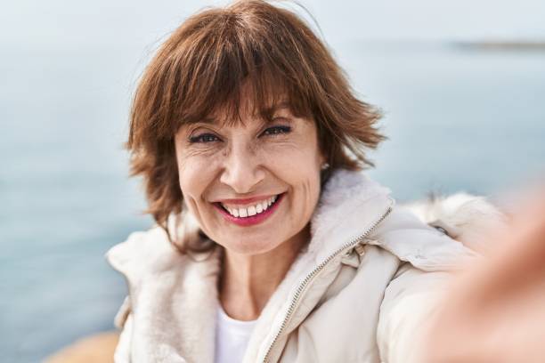 istock Middle age woman smiling confident making selfie by camera at seaside 1446925778