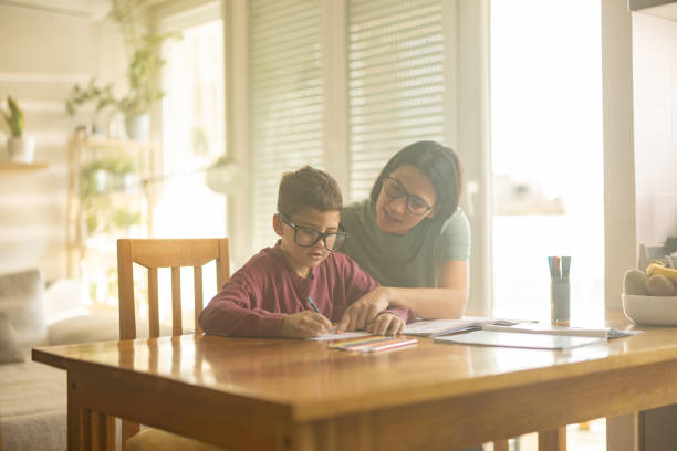 istock Mom helping son do his homework 1446925959