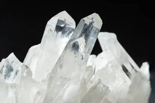 Close up of Pure Quartz Crystal Cluster on Black Background. Natural growing crystals of Clear Quartz