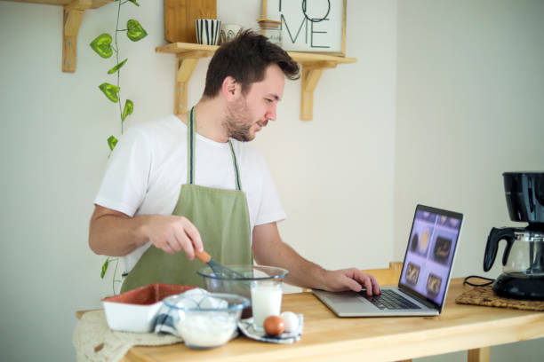 istock Young Man Making Cake With Recipe , Man In The Kitchen 1446932507