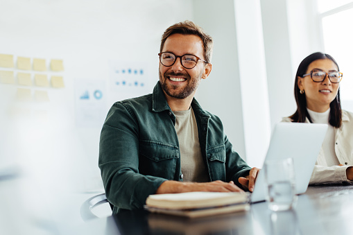 Happy business man listening to a discussion in an office