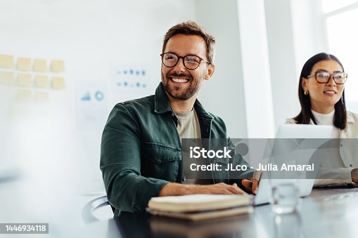 istock Happy business man listening to a discussion in an office 1446934118
