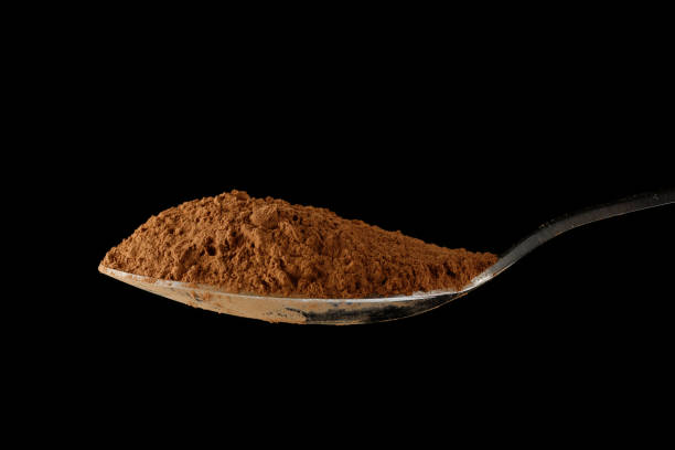 istock Cocoa powder on a spoon on black close-up 1446935305