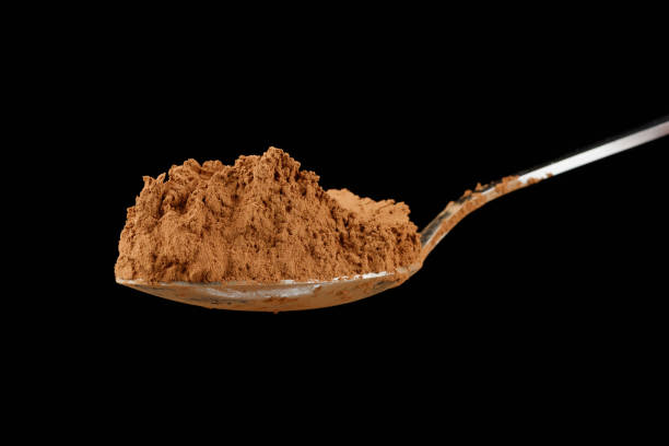 istock Cocoa powder on a spoon on black close-up 1446935345