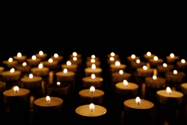 istock Many candle flames glowing on dark background. 1446935370