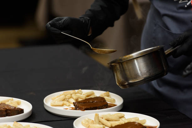 istock chef is serving pasticada with gnocchi, beef stew in a sauce. Croatian cuisine 1446935540