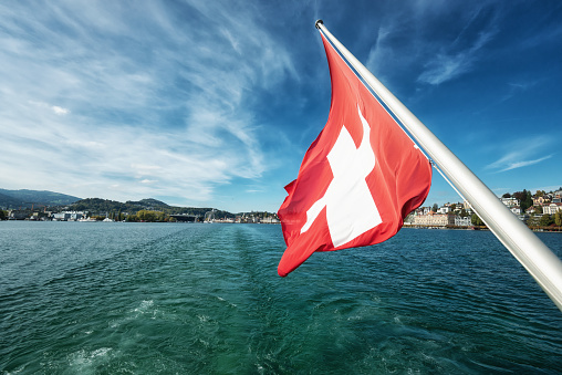 Leaving Lucerne on boat in direction Altdorf with weaving Swiss flag