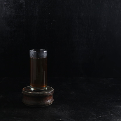 A empty old bottle with a rubber stopper is isolated on a gray background.  The picture has an old sepia and grainy picture effect.  Can be use to symbolize starting out, future, empty, etc.   Empty space for text.