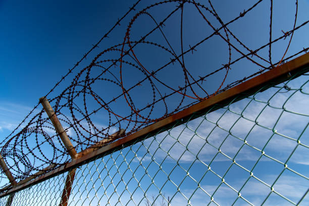 istock the blue autumn sky over the rusty barbed wire 1446940503