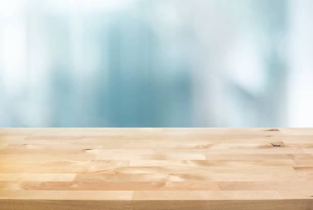 Selective focus.Top of wood  table with blur window glass  background. stock photo