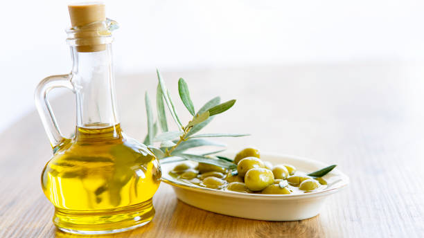 Olive oil and olive berries are on the wooden table stock photo
