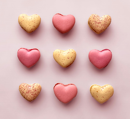 Valentines Day Pink and Cream Heart Shaped French Macaroon Cookies Dessert Food Abstract Background Love Concept, Hearts Background Pattern with Macaroons in a Row, Flat Lay Shot from Directly Above