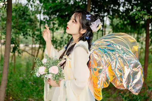 An Asian beauty in a Chinese costume,  , was in the outdoor flowers